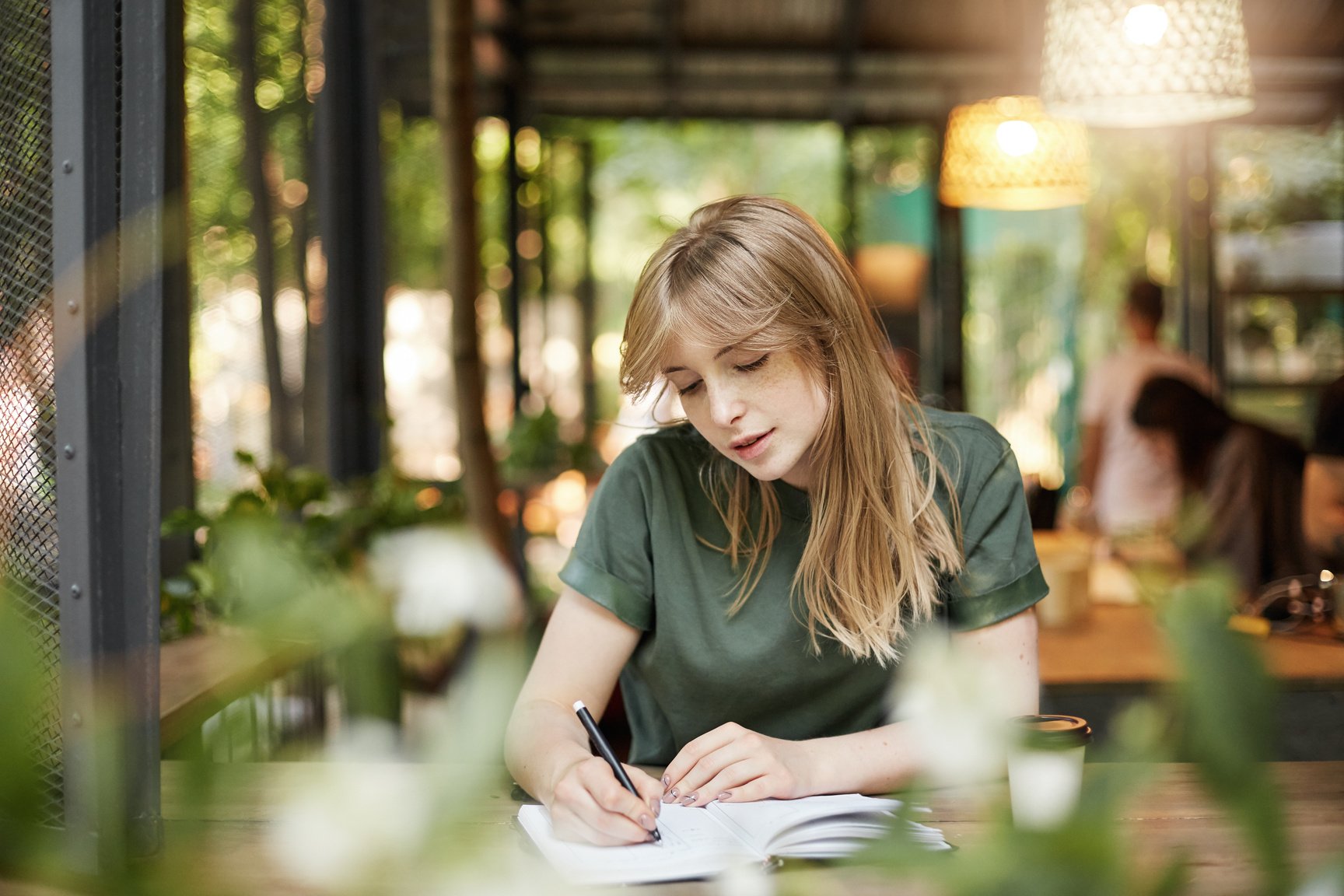 Portrait of a young blonde student screenwriter girl writing her